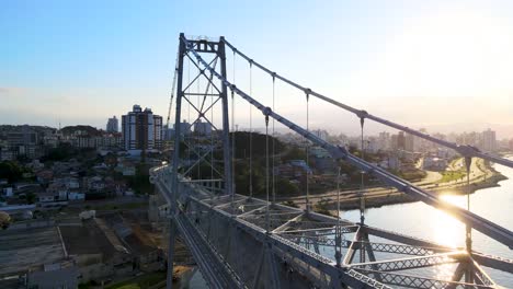 Aerial-scene-of-drone-flying-low-and-low-over-cable-stayed-suspension-bridge-Hercílio-Luz-in-Florianópolis-capital-of-santa-catarina-and-urban-scenery-santa-catarina-postcard