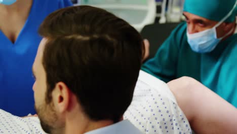 doctor examining pregnant woman during delivery while man holding her hand in operating room