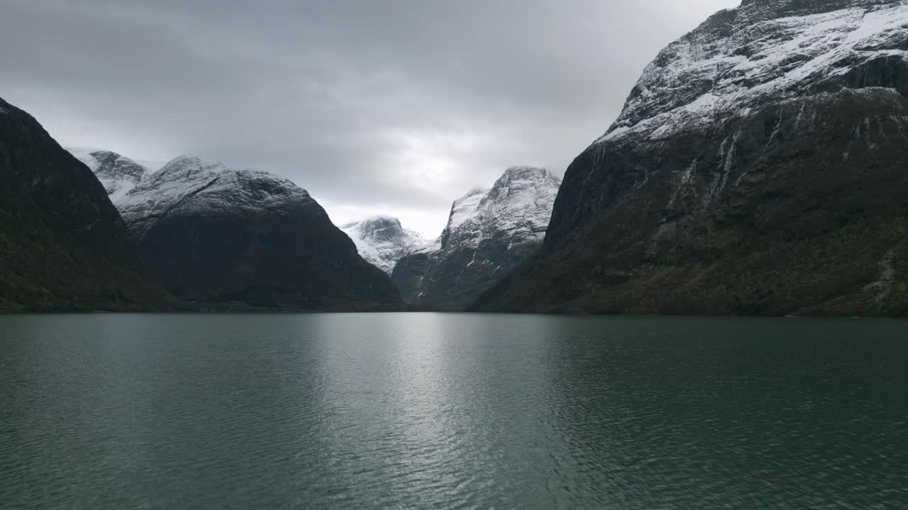 Maestoso Lago Lovatnet in Norvegia con montagne innevate e cieli nuvolosi, scena naturale tranquilla
