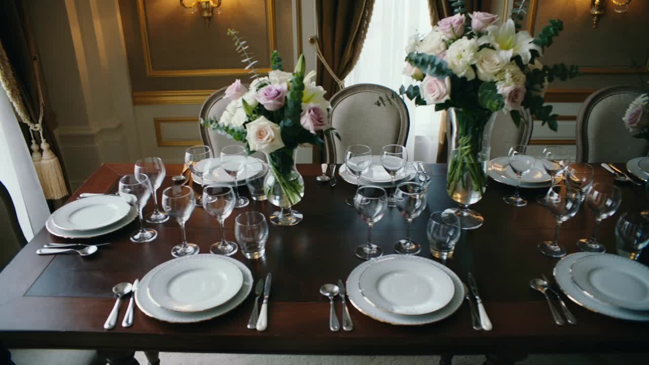 Recording starting camera approaching formal dining room table, showing three glass vases