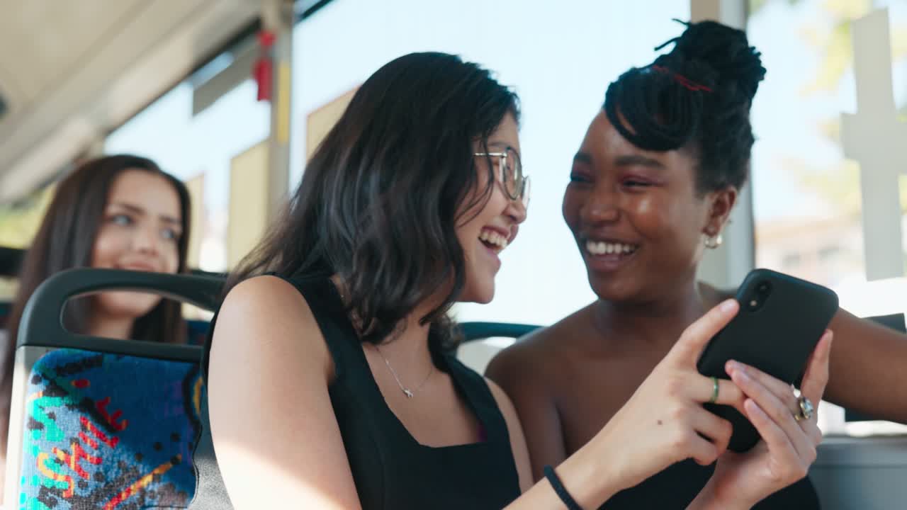 Two pretty women of different nationalities ride the bus, students return from university in a