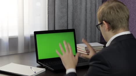 Man-have-video-call-conference-on-laptop-with-green-screen.-Distance-work-online