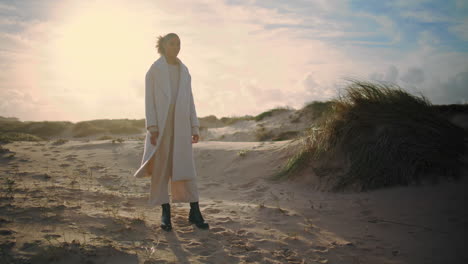 silueta de mujer posando a la luz del sol en las dunas de arena. hermosa modelo tranquilo admirando