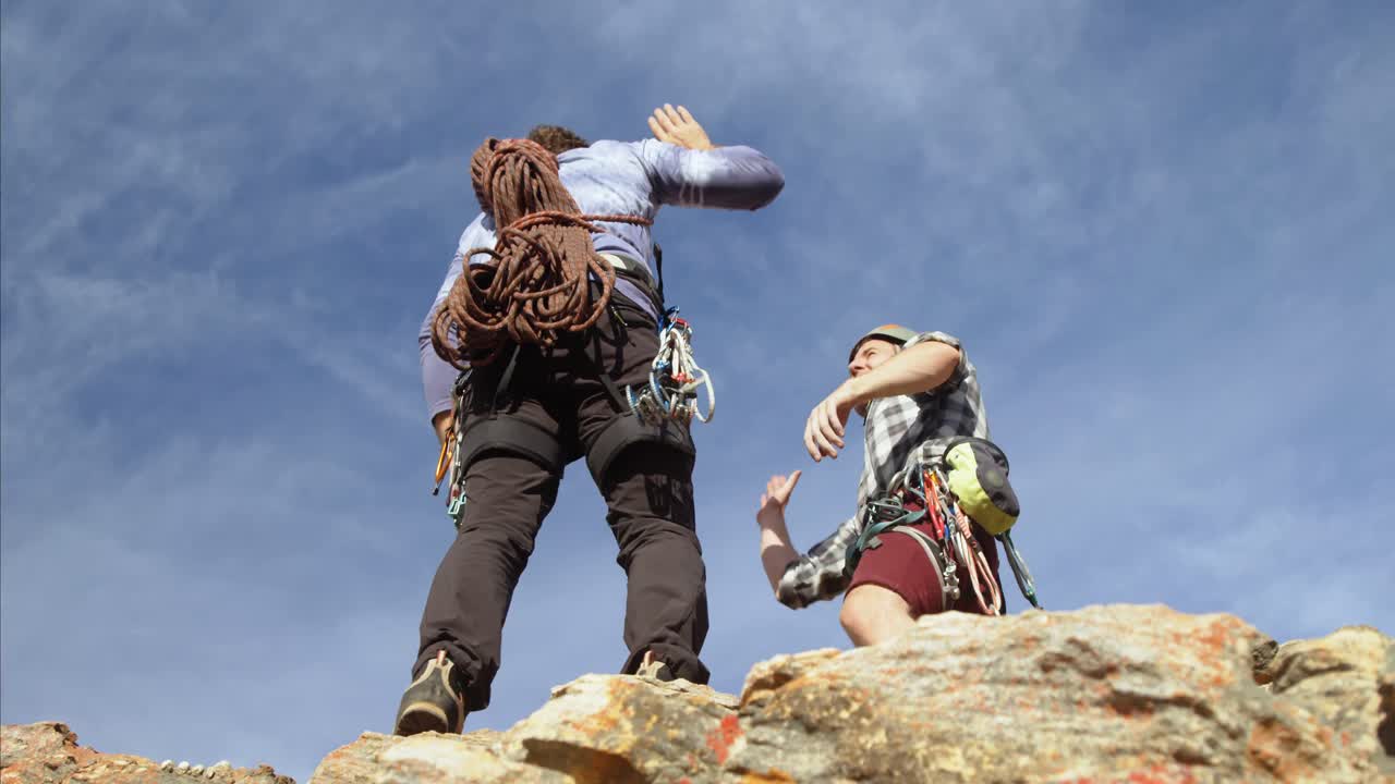 escaladores alcanzando con éxito la cima de la montaña 4k