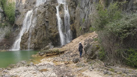 Aerial-view-of-waterfall-in-the-middle-of-the-mountain.--People-discovering-a-nature-landscape.