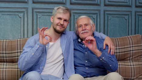 Different-male-generations-family-of-senior-father-and-adult-son-or-grandson-showing-ok-gesture-sign