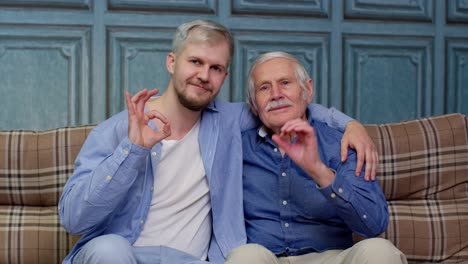 diferentes generaciones masculinas familia de padre mayor y hijo o nieto adulto mostrando el signo de gesto ok