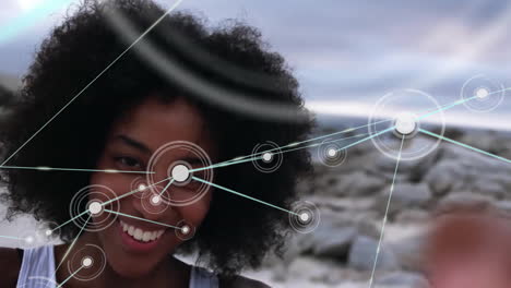 animación de la red de conexiones con íconos sobre mujer biracial por mar