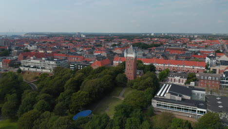 Slider-aerial-view-over-the-monument-of-Water-Tower-in-Esbjerg,-Denmark.-This-iconic-historical-landmark-is-on-the-top-of-a-cliff-and-on-the-roof-can-be-appreciate-a-scenic-panorama-of-the-city