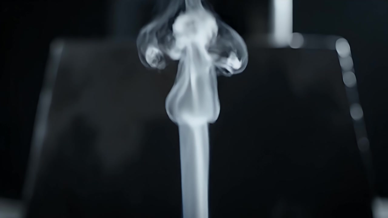 Thin Stream of White Smoke Rising Against a Dark Background