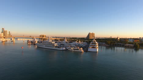 panoramic video of a bay with luxury yachts docked on port near a beautiful cityscape | yachts docked on port in miami, biscayne bay video background in 4k