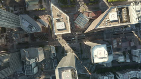 AERIAL:-Slow-uplifting-birds-eye-View-flight-over-Downtown-Los-Angeles-California-Grand-Avenue-in-beautiful-Sunrise-Light-with-view-of-skyscraper-rooftops-and-car-traffic-passing