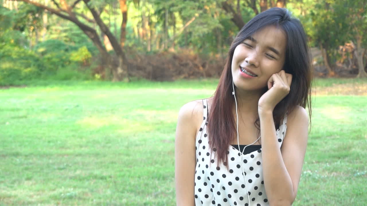 귀여운 여자가 음악 비트에 따라 듣고 춤을 춘다.