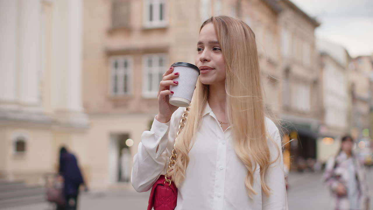 Happy woman girl enjoying drinking morning coffee hot drink relaxing taking a break in city street