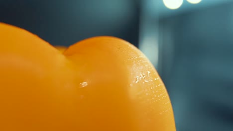 un macro de cerca hermoso plano de una pimienta amarilla dulce húmeda en un soporte giratorio de 360, brillantes gotas de agua sudorosas, iluminación de estudio cinematográfico, cámara súper lenta, 120 fps, movimiento suave, full hd