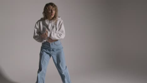 full length studio shot of young woman having fun dancing against grey background 4