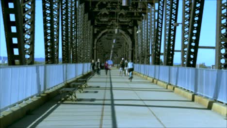 un puente peatonal con gente y un ciclista