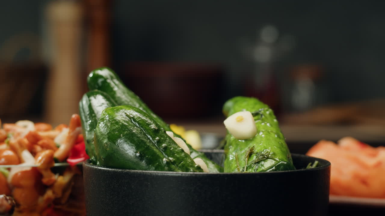Close-up of fermented cucumbers with garlic and dill on plate. Preservation of vegetables in glass jars. Fermentation preserved cucumbers with spices. Russian cuisine.