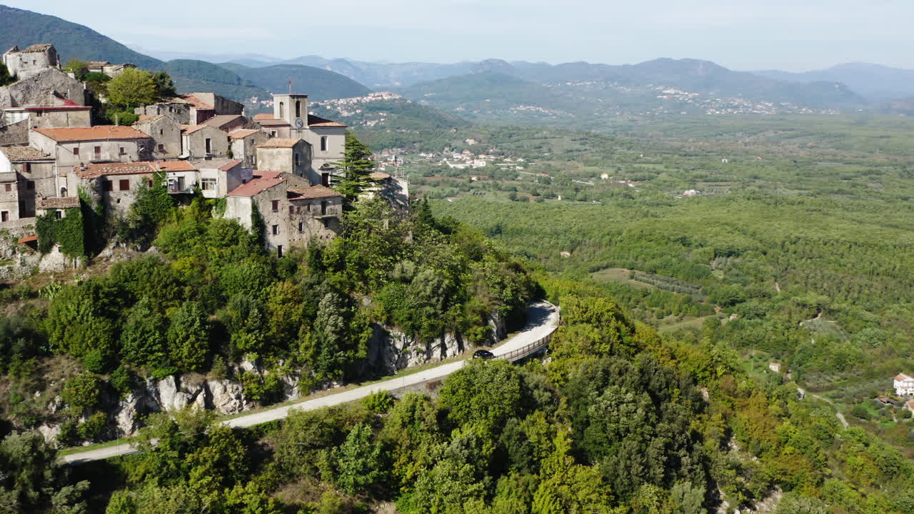 Splendida ripresa aerea di un'auto a noleggio che percorre il centro storico collinare di Roccaravindola, nella regione Molise in Italia.