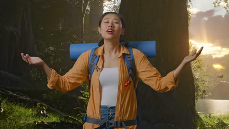 asian female hiker with mountaineering backpack smiling and spreading arms enjoy looking the view around while exploring forest nature