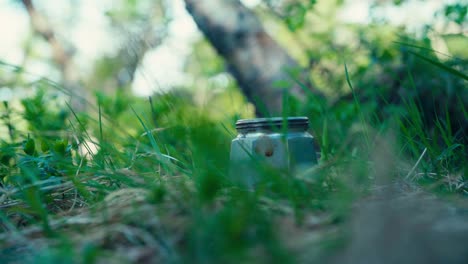 preparando café al aire libre con una olla de moka en un terreno cubierto de hierba
