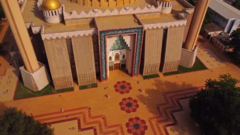 top down aerial of the square in front of a beautiful mosque. the drone pulls back and reveals the stunning abuja national mosque in nigeria, africa