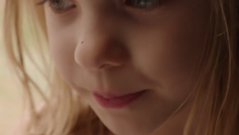 beautiful slow motion close up portrait of a little girl's face as she looks toward the camera