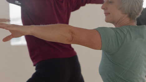 retrato de clase de yoga de una mujer madura ejerciendo un estilo de vida saludable practicando pose de guerrero disfrutando de un entrenamiento físico en grupo en el estudio