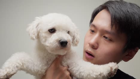 장난감 푸들 품종 개 와 함께 중국인 젊은 남자 의 초상화