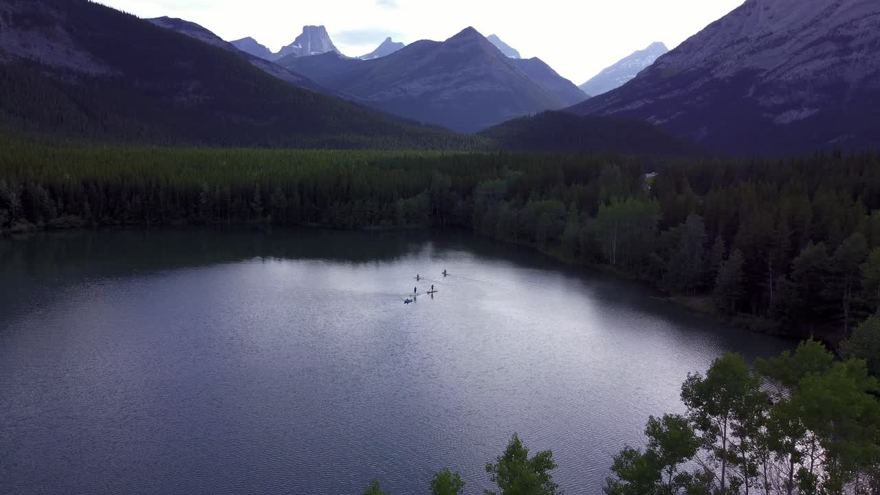 paddle boarders y bote en un lago de montaña sacar rockies kananaskis alberta canada