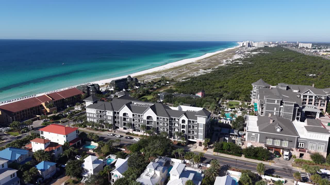 Drone orbit of seaside neighborhood with white sandy beach and houses, apartments in sunny weather, 30A, Florida, USA