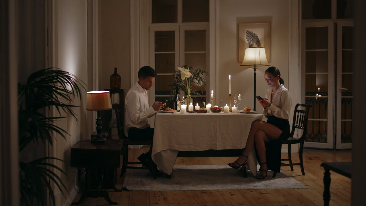 만적인 저녁에 모바일을 보는 중독자. 서로를 무시하는 커플