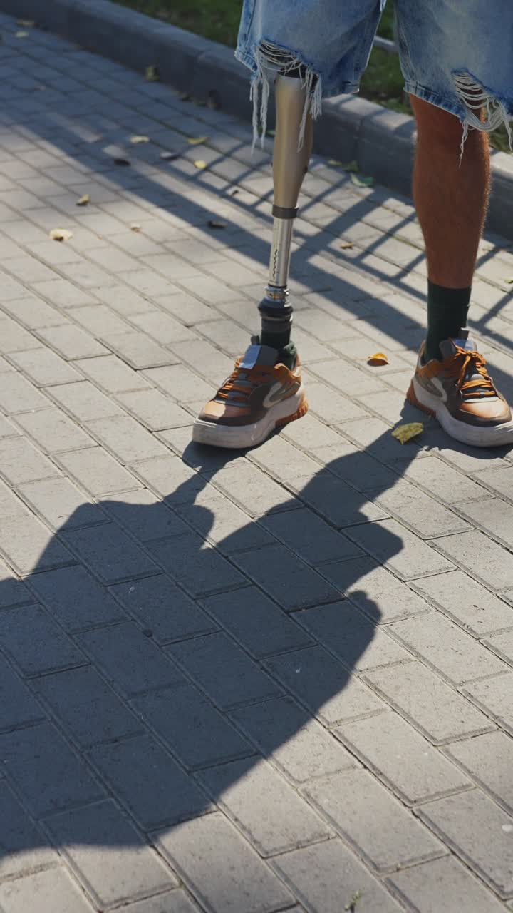 Person with prosthetic leg walking on city pavement