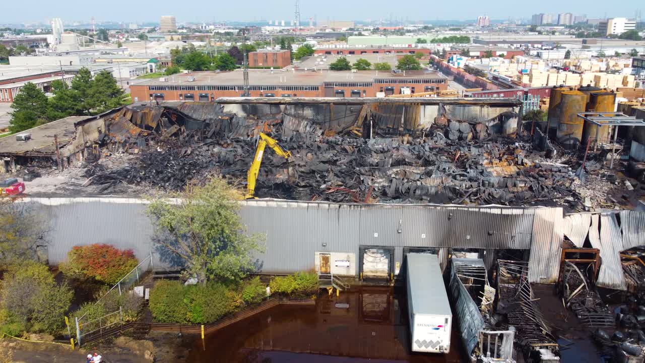 캐나다 토론토 에서 대형 화재 가 발생 한 후 의 유적 을 청소 하는 발굴기