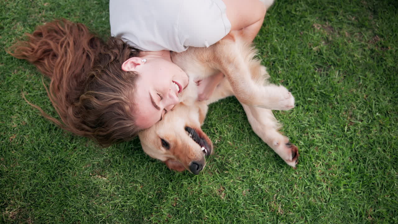 Woman and dog lying on grass