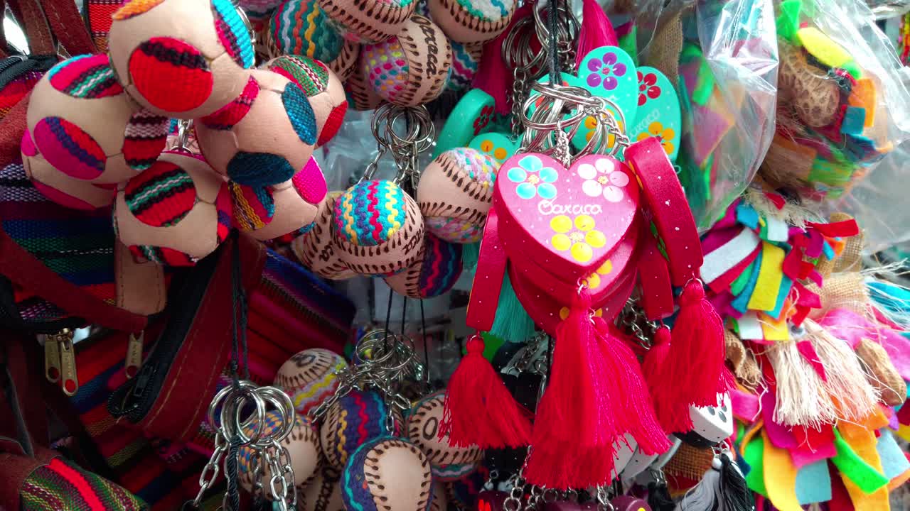 Close-up shot of traditional handmade keychains and souvenirs hanging at a street stall in Oaxaca