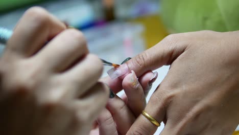 woman getting gel nails extension by the beautician