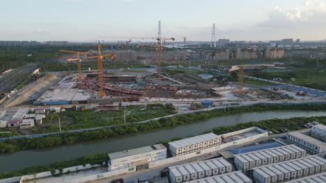 aerial view of cranes and constuction site next to a chinese river in shanghai