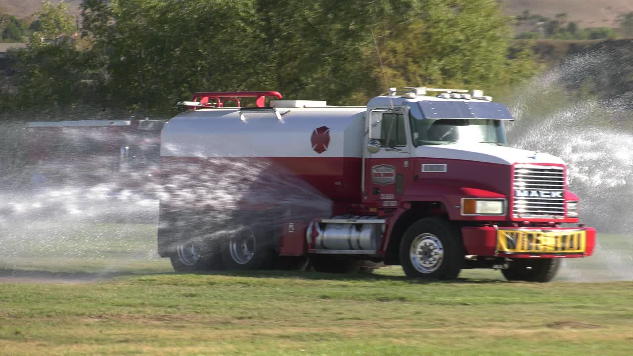 camión rociando agua para mantener viva la hierba