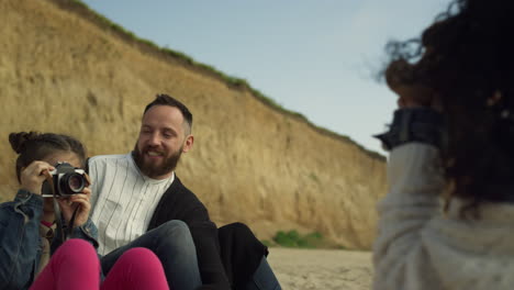 Little-child-play-photographer-at-beach-holiday.-Smiling-family-rest-on-vacation