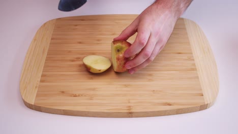 disparo de ángulo alto de una manzana roja siendo cortada en trozos
