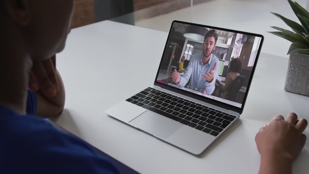 Mid section of african american woman having a video call on laptop with male colleague at office