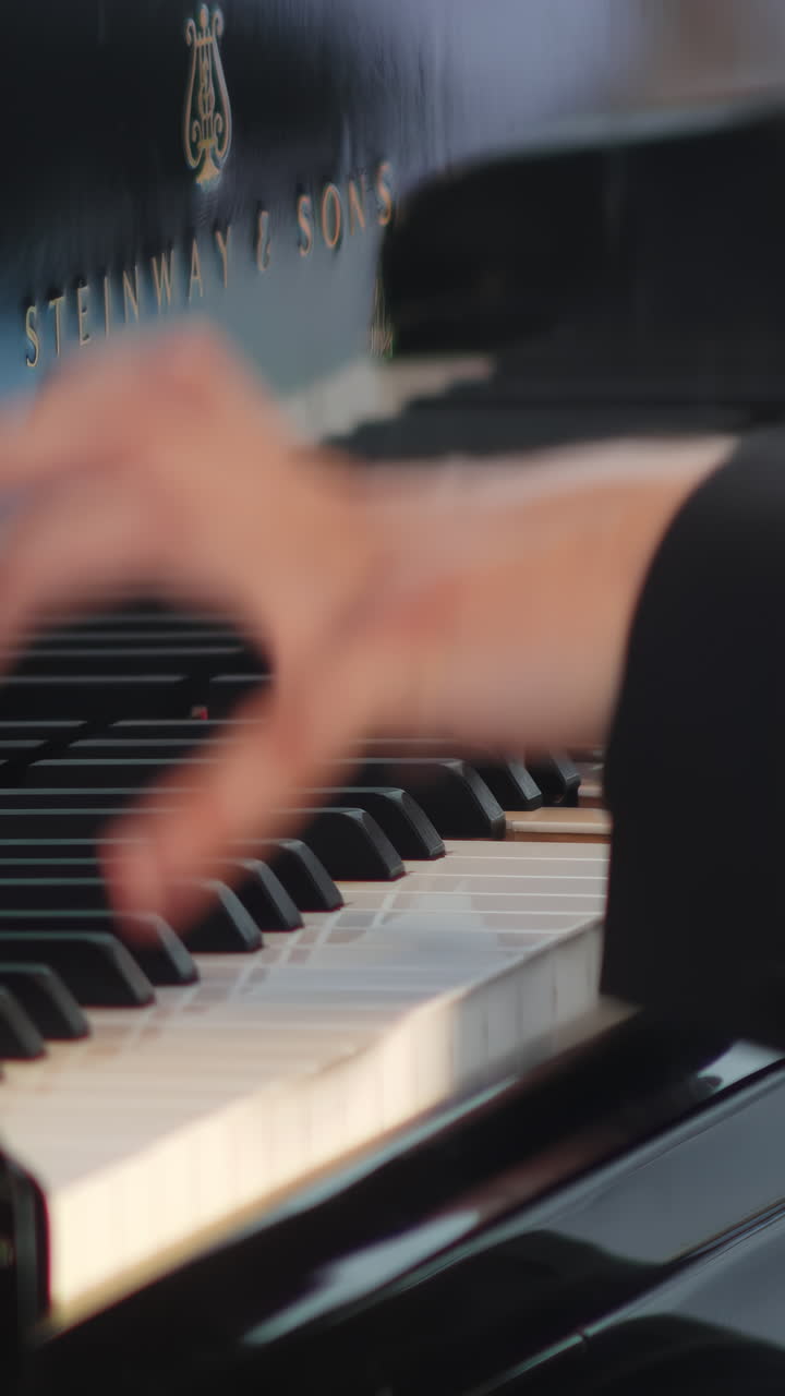 primer plano de las manos tocando un piano steinway