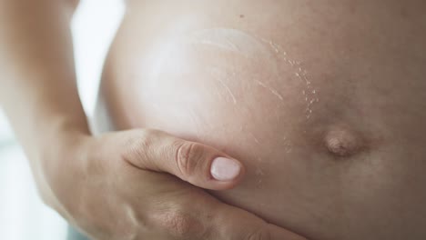 pregnant woman and heart shape made of body lotion.