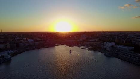 Aerial-descending-shot-over-the-bay-of-Helsinki,-Finland-at-sunset