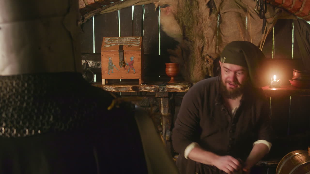 el comerciante barbudo compra el botín del aventurero en la taberna. el hombre barbudo feliz da un bolso con monedas al caballero que comercia en la tienda. mazmorras y dragones cosplay