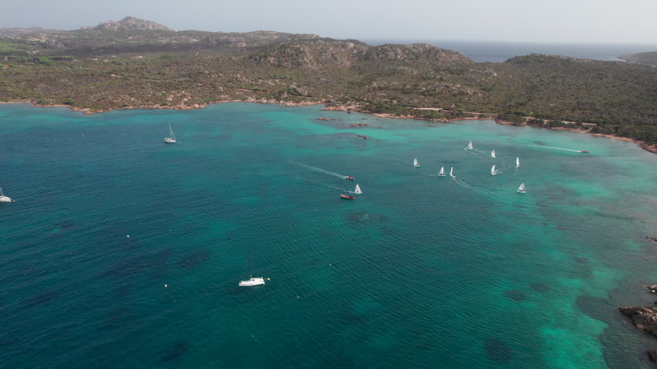 Magnifique vue aérienne en mouvement circulaire au-dessus de voiliers naviguant sur l'île de Caprera en Sardaigne