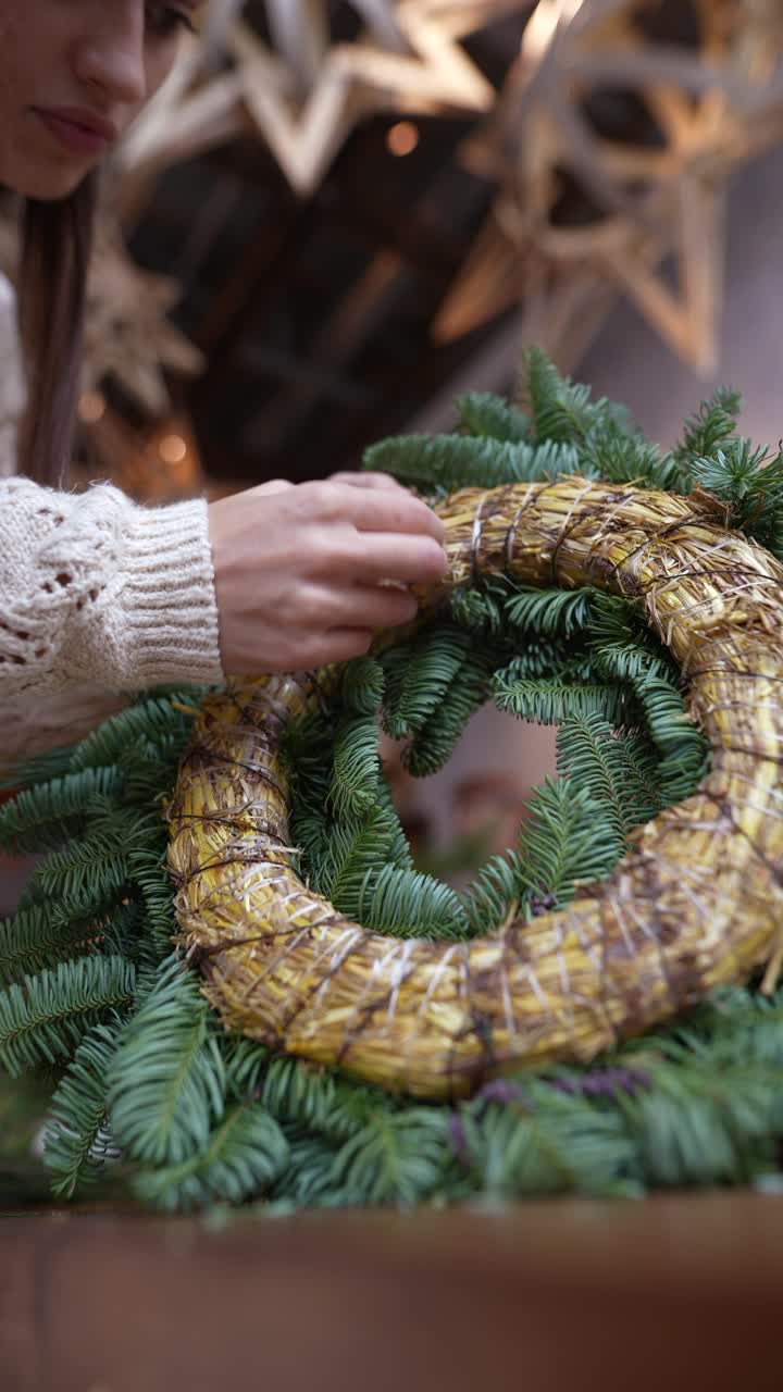 mujer haciendo una corona de paja de navidad