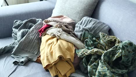 messy pile of clothes on sofa