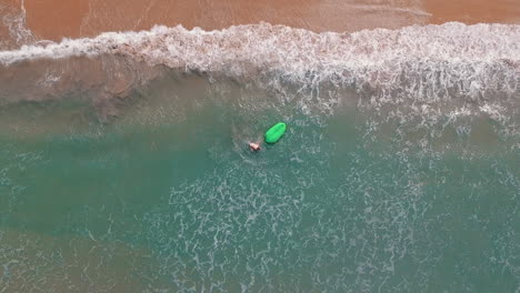 joven blanco caminando por una playa de agua azul clara en una isla tropical